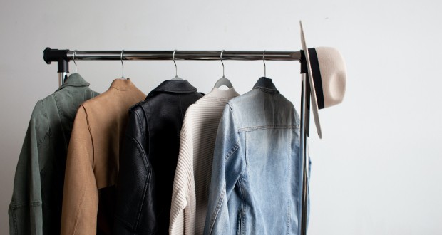 Men's jackets and a hat hanging on a metal clothing rack