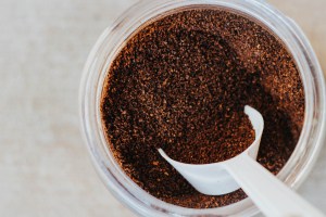 Closeup of coffee grounds with a white scoop