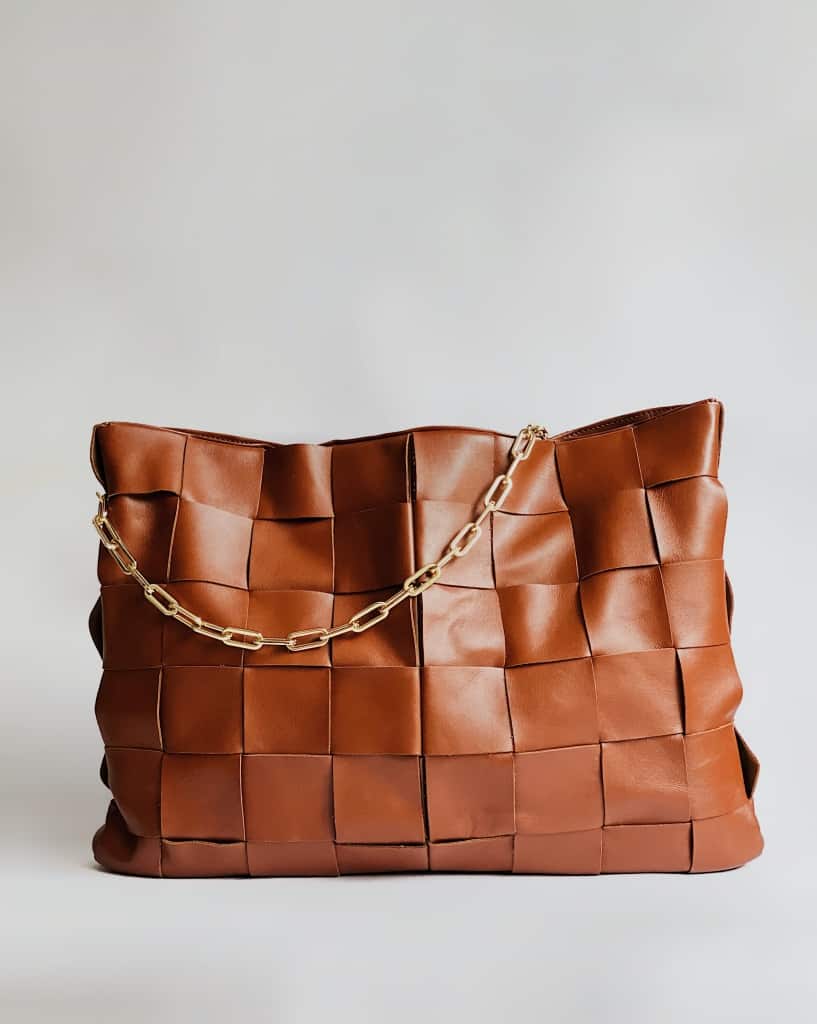 Brown woven leather purse against a blank background